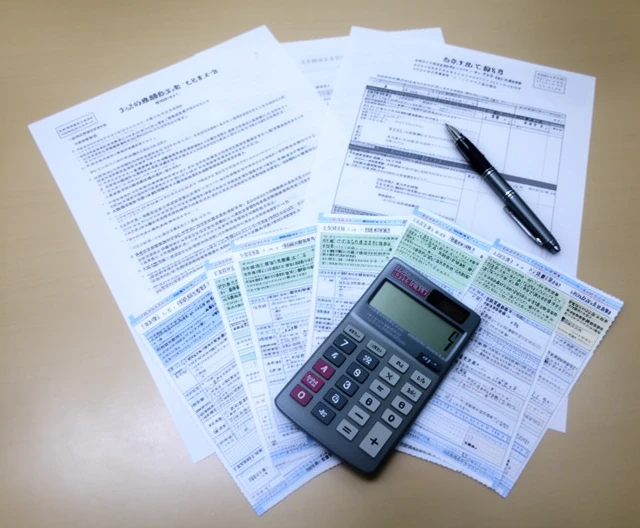 Contract, dividend vouchers and a calculator spread across a desk